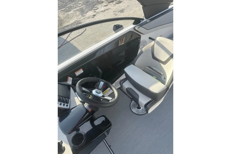 Slide: The Image of 2025 Yamaha Boats AR220 cockpit with steering wheel and captain's chair. - 17