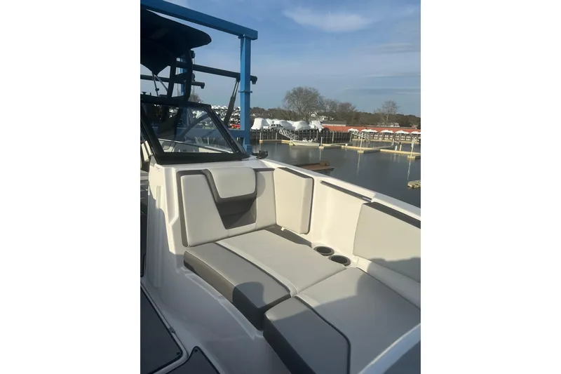 Slide: The Image of 2025 Yamaha Boats AR220 interior with sleek seating, dockside view, and modern design. - 20