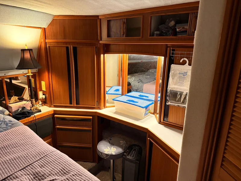 Slide: The Image of 1988 Sea Ray 415 Aft Cabin interior with wooden furnishings. - 25