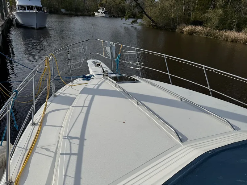Slide: The Image of 1988 Sea Ray 415 Aft Cabin docked on a calm river. - 36
