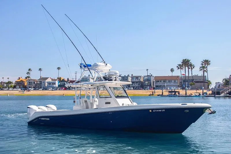 The Image of 2013 Everglades 355 Center Console boat on water near coastal homes and palm trees. - 1