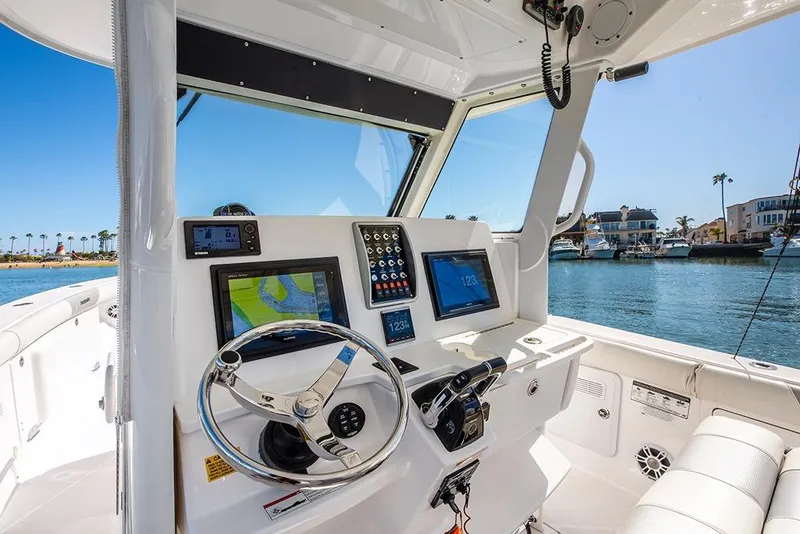Slide: The Image of 2013 Everglades 355 Center Console boat interior with navigation equipment and waterfront view. - 10