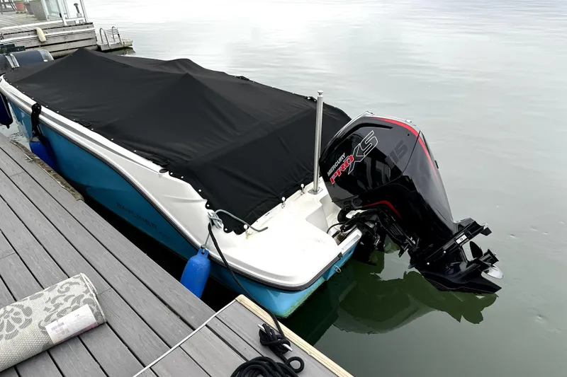 Slide: The Image of 2024 Bayliner Element M19 boat docked with black cover and Mercury outboard motor. - 13