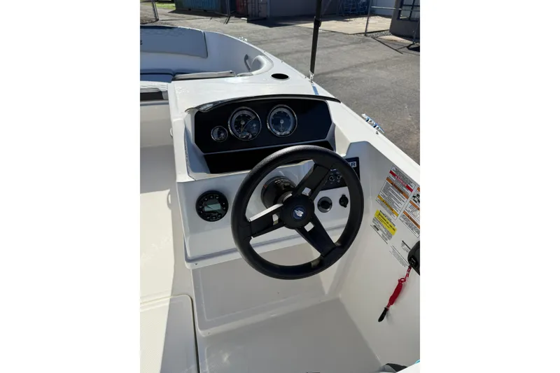 Slide: The Image of 2024 Bayliner Element M19 boat dashboard with steering wheel and gauges. - 7