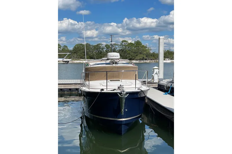 The Image of 2025 Ranger Tugs R-27 Seakeeper Ride docked, featuring Garmin equipment, under a clear blue sky. - 0