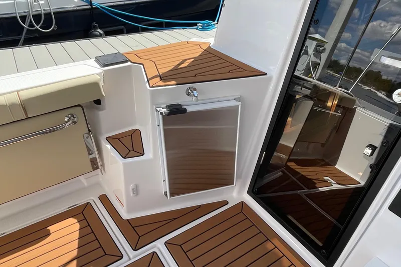 Slide: The Image of 2025 Ranger Tugs R-27 Seakeeper Ride boat interior with teak flooring and seating. - 10
