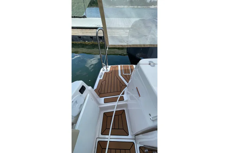 Slide: The Image of 2025 Ranger Tugs R-27 Seakeeper Ride boat deck with wood-patterned flooring. - 12