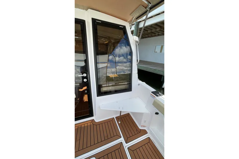 Slide: The Image of 2025 Ranger Tugs R-27 Seakeeper Ride, featuring sleek deck design and modern window detailing. - 13