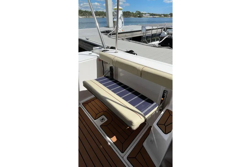 Slide: The Image of 2025 Ranger Tugs R-27 Seakeeper Ride boat seat with striped cushion, dockside view. - 18