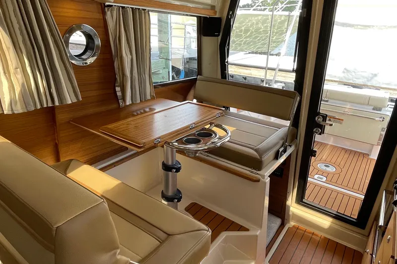 Slide: The Image of Interior of 2025 Ranger Tugs R-27 Seakeeper Ride, featuring elegant seating and wooden accents. - 26