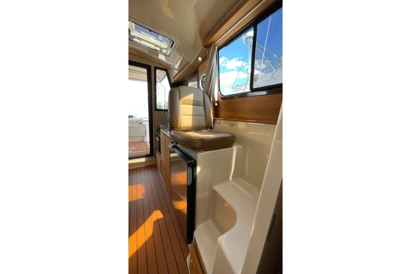 Slide: The Image of Interior of 2025 Ranger Tugs R-27 Seakeeper Ride with wood flooring and seating. - 34