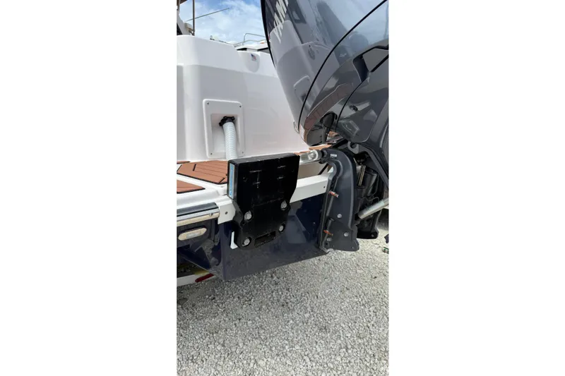 Slide: The Image of 2025 Ranger Tugs R-27 boat engine and transom detail on gravel surface. - 4