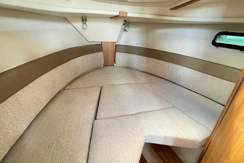 Slide: The Image of 2025 Ranger Tugs R-27 Seakeeper Ride interior cabin with cushioned seating. - 40