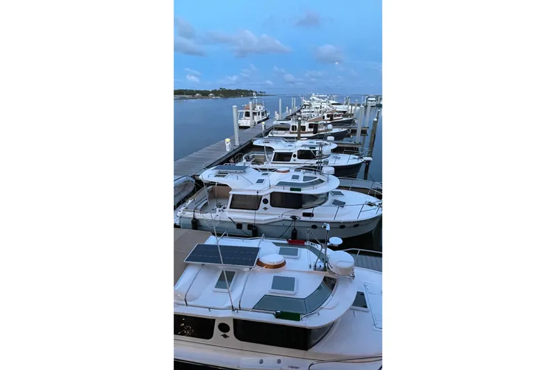 Slide: The Image of Docked Ranger Tugs R-27 boats, 2025 model, at a marina during sunset. - 41
