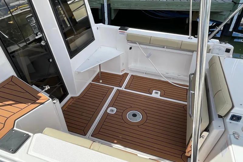Slide: The Image of 2025 Ranger Tugs R-27 Seakeeper Ride boat interior with teak flooring and seating. - 8