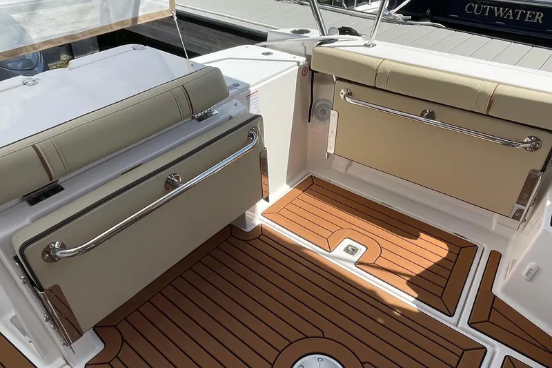 Slide: The Image of 2025 Ranger Tugs R-27 Seakeeper Ride interior with cushioned seating and teak-style flooring. - 9