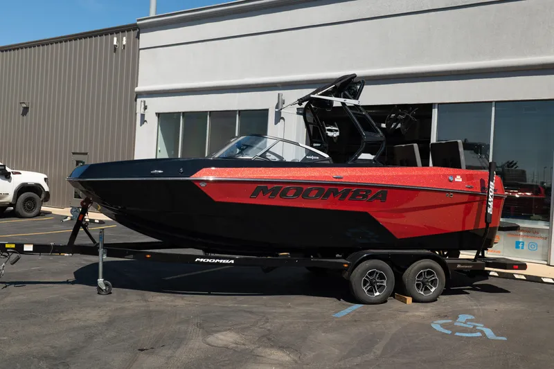 Slide: The Image of 2025 Moomba Max boat in red and black on a trailer outside a dealership. - 21