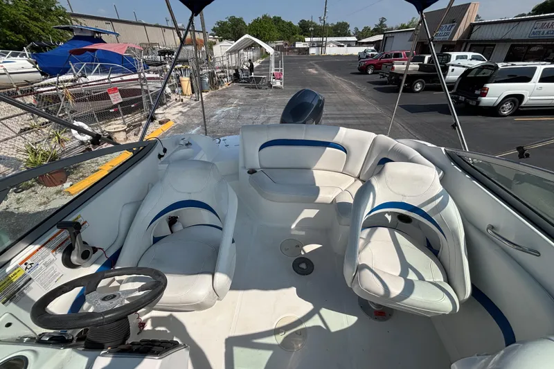 Slide: The Image of 2013 Hurricane SunDeck 2200 DC OB boat interior with white seating and steering wheel. - 12