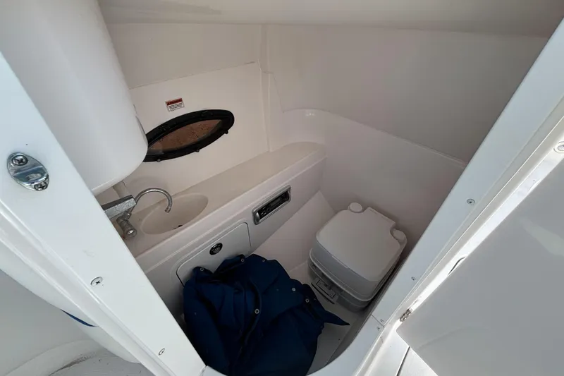Slide: The Image of 2013 Hurricane SunDeck 2200 DC OB boat interior with sink and portable toilet. - 15