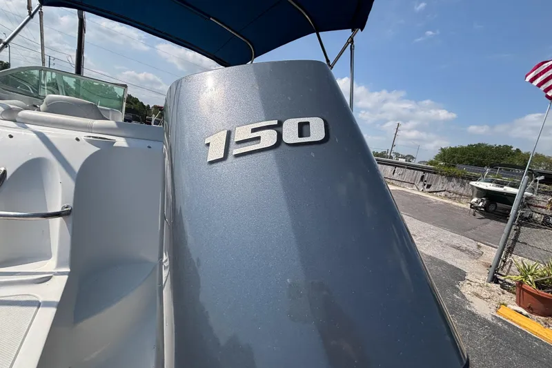 Slide: The Image of 2013 Hurricane SunDeck 2200 DC OB boat with 150 horsepower engine, docked under blue sky. - 29