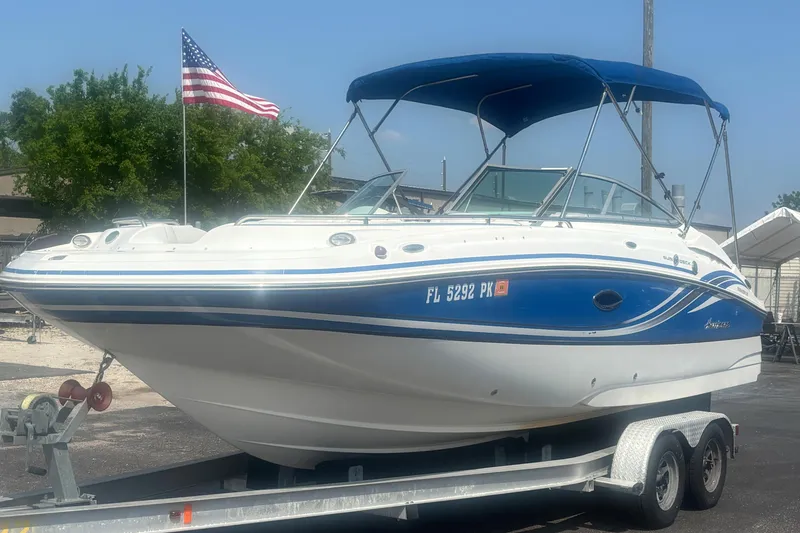 Slide: The Image of 2013 Hurricane SunDeck 2200 DC OB boat on trailer with American flag in background. - 9