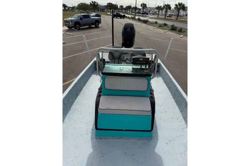 Slide: The Image of 2018 Haynie 25' Magnum boat with teal seating, parked in a lot. - 16