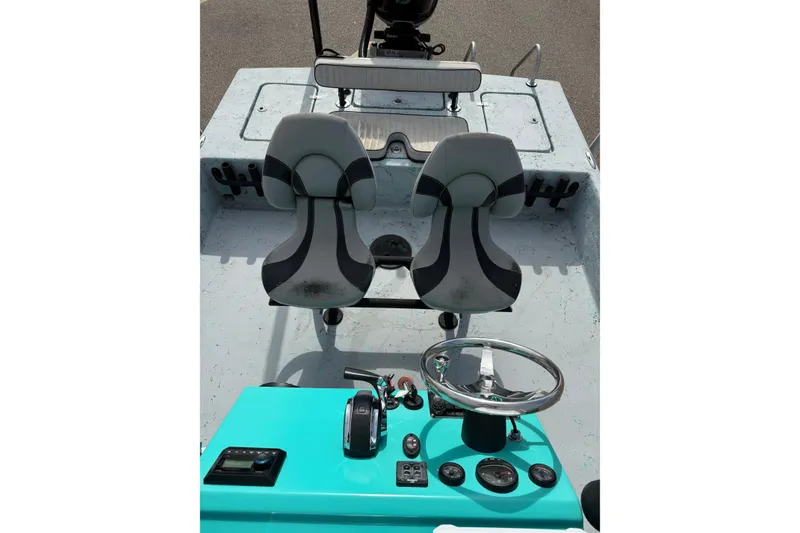 Slide: The Image of 2018 Haynie 25' Magnum boat interior with dual seats and turquoise control panel. - 19