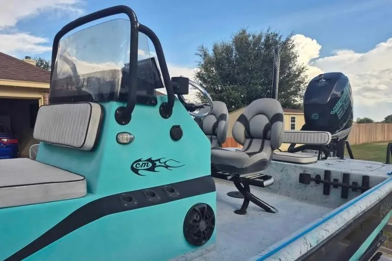 Slide: The Image of 2018 Haynie 25' Magnum boat with teal exterior and comfortable seating. - 2