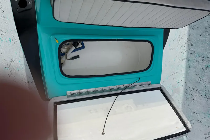Slide: The Image of Open storage compartment on a 2018 Haynie 25' Magnum boat, featuring turquoise interior. - 23