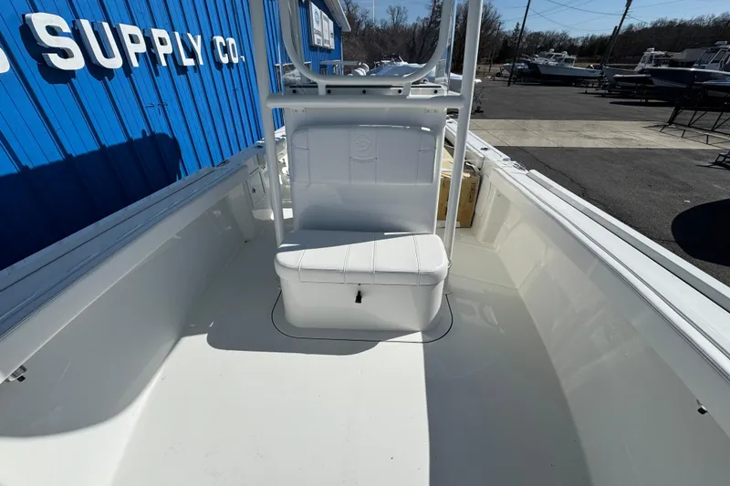 Slide: The Image of 2026 Parker 230 Coastal Elite boat interior with white seating, docked near blue building. - 10