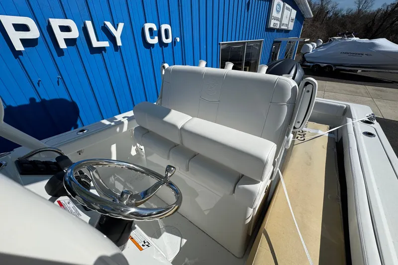 Slide: The Image of 2026 Parker 230 Coastal Elite boat with white seating and chrome steering wheel. - 13