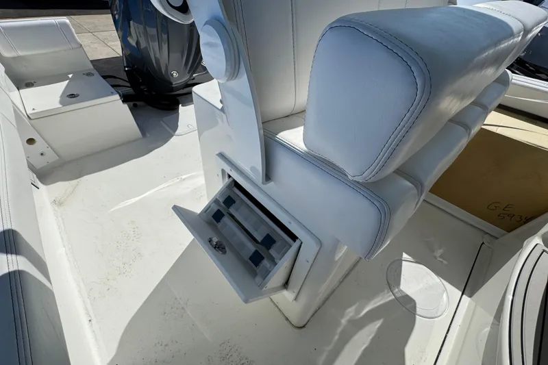 Slide: The Image of 2026 Parker 230 Coastal Elite boat interior with white seating and storage compartment. - 17