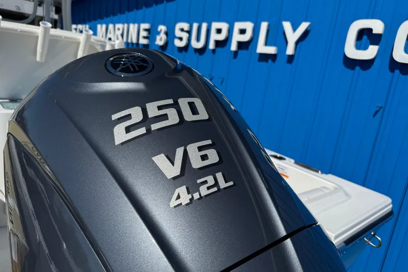 Slide: The Image of Outboard motor with "250 V6 4.2L" text, near a marine supply store. Parker 230 Coastal Elite 2026. - 21