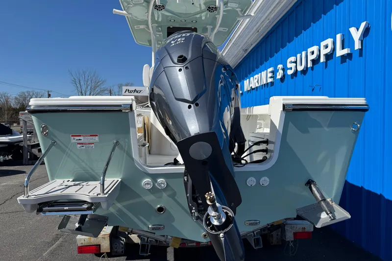 Slide: The Image of 2026 Parker 230 Coastal Elite boat at marine supply store, featuring powerful outboard motor. - 4