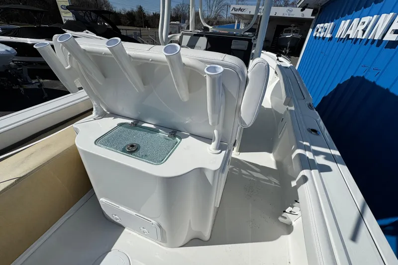 Slide: The Image of 2026 Parker 230 Coastal Elite boat interior with rod holders and storage compartment. - 7
