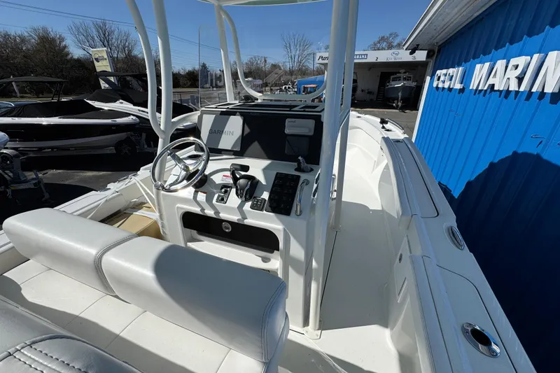 Slide: The Image of 2026 Parker 230 Coastal Elite boat interior with steering wheel and Garmin navigation system. - 8