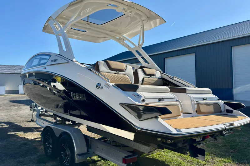 Slide: The Image of 2022 Yamaha Boats 275SD on trailer, showcasing sleek design and spacious seating. - 11