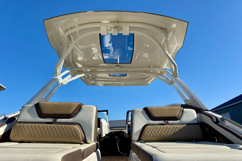 Slide: The Image of 2022 Yamaha Boats 275SD interior with luxurious seating and sleek design under a clear blue sky. - 12