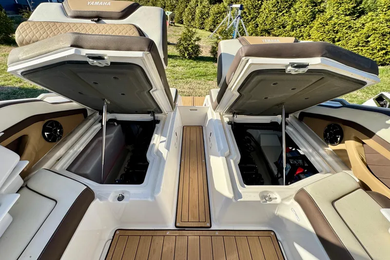 Slide: The Image of 2022 Yamaha Boats 275SD with open storage compartments and luxurious seating. - 16