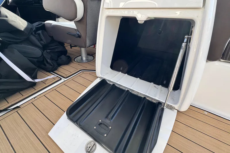 Slide: The Image of Open storage compartment on 2022 Yamaha Boats 275SD, featuring teak flooring and seating. - 17