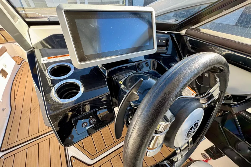 Slide: The Image of 2022 Yamaha Boats 275SD dashboard with touchscreen, steering wheel, and cup holders. - 24