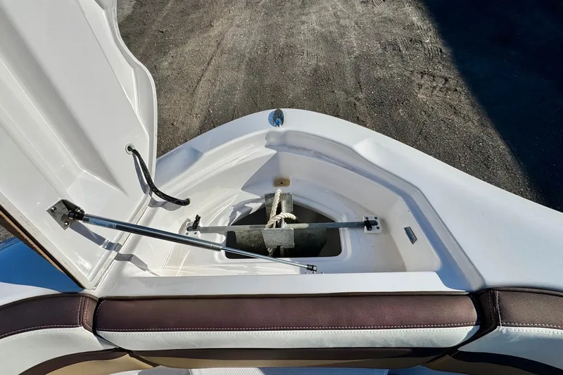 Slide: The Image of 2022 Yamaha Boats 275SD anchor compartment with open hatch and seating. - 30