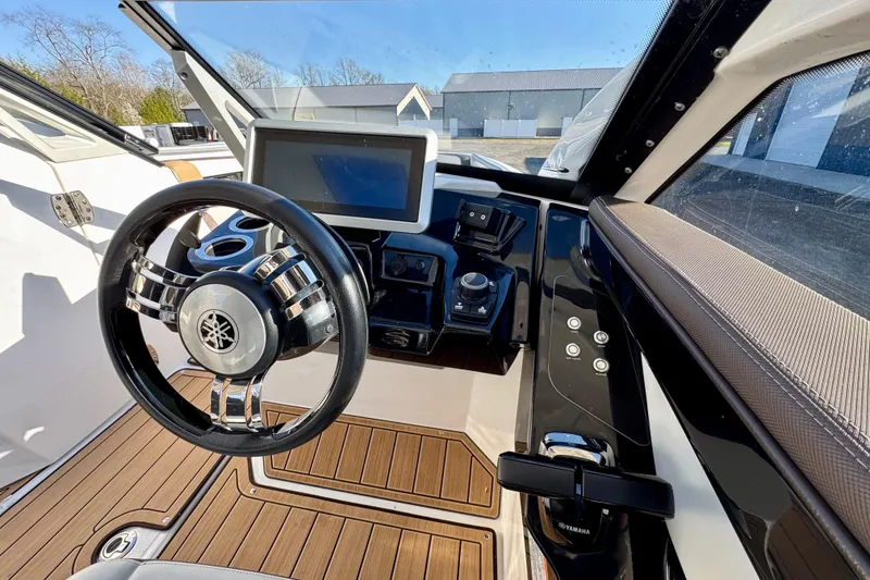 Slide: The Image of 2022 Yamaha Boats 275SD helm with steering wheel, touchscreen, and controls. - 6