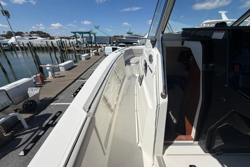 Slide: The Image of 2026 Pursuit S 358 Sport boat docked at marina under clear blue sky. - 100