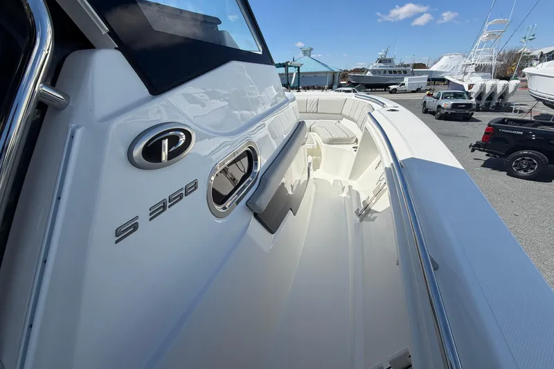 Slide: The Image of 2026 Pursuit S 358 Sport boat, sleek design, docked with clear blue sky background. - 104