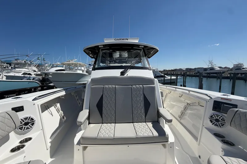 Slide: The Image of 2026 Pursuit S 358 Sport boat interior with sleek seating and modern design at a marina. - 107