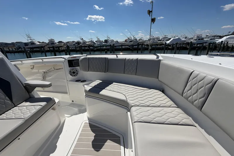 Slide: The Image of Luxurious seating on 2026 Pursuit S 358 Sport boat, docked with other vessels in background. - 108