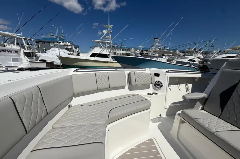 Slide: The Image of 2026 Pursuit S 358 Sport boat interior with luxurious seating in a marina setting. - 114