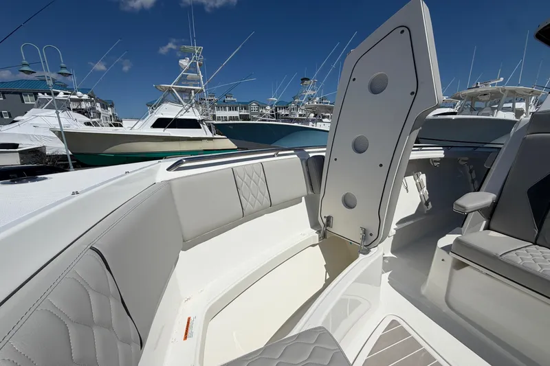 Slide: The Image of 2026 Pursuit S 358 Sport boat interior with open storage compartment, docked among other boats. - 120