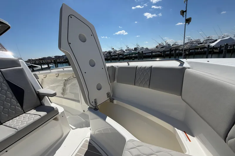 Slide: The Image of 2026 Pursuit S 358 Sport boat interior with open storage compartment, docked at marina. - 122
